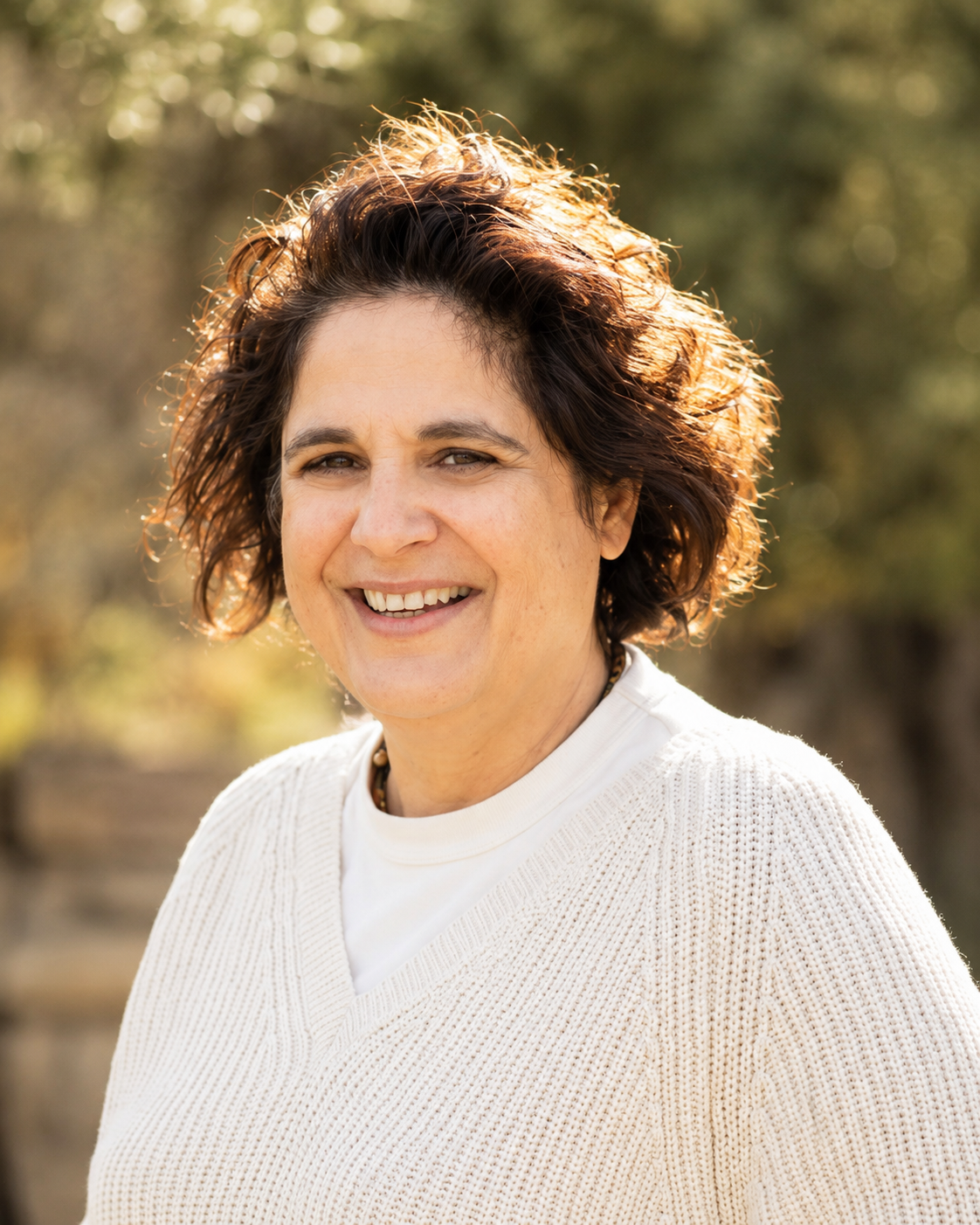 Fatma Kiymaz, founder of Aila, photographed from the shoulders up in soft natural daylight, wearing neutral tones with a calm, warm expression.